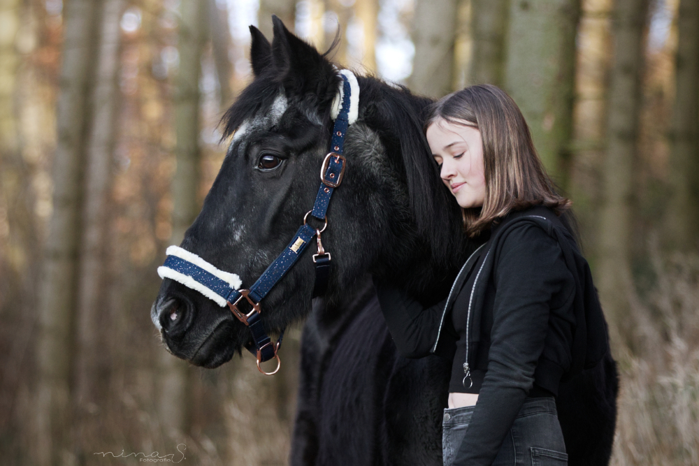 Ein Mädchen lehnt sich vertrauensvoll an den Hals ihres Pferdes. Ich halte deine Verbundenheit zu deinem Tier fest.